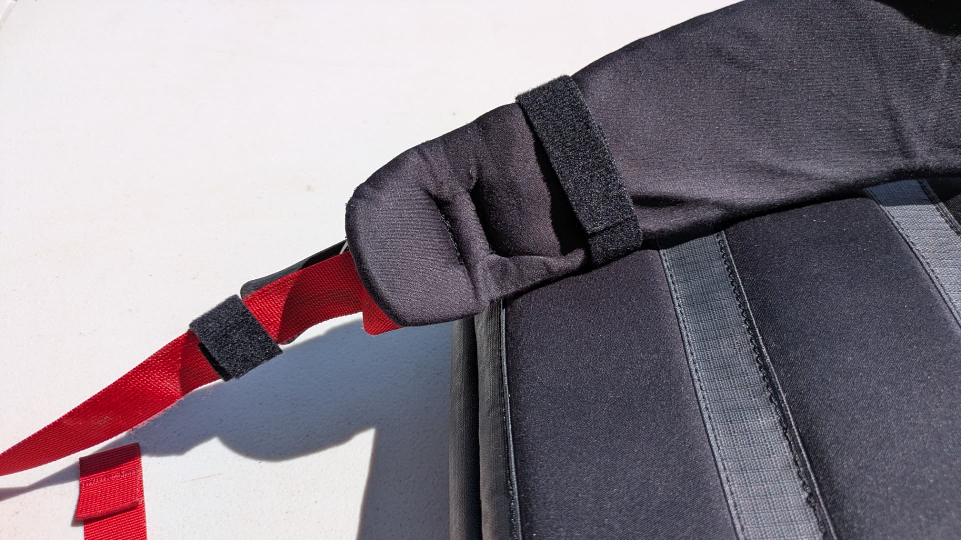 Velcro strap wrapped and pressed around a backpack shoulder strap