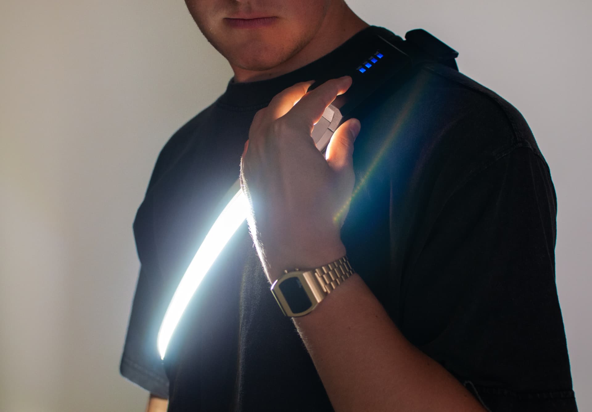 A person wearing Body StrapLights® over the shoulder and adjusting the light at the shoulder control